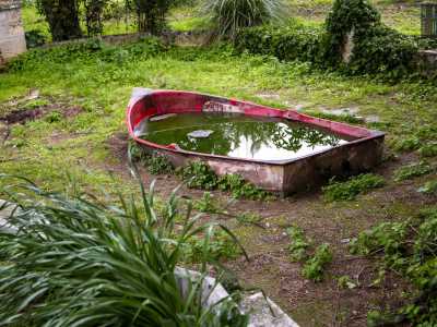 A sinistra ci sorprende poi un pittoresco gozzo rosso pieno di acqua piovana